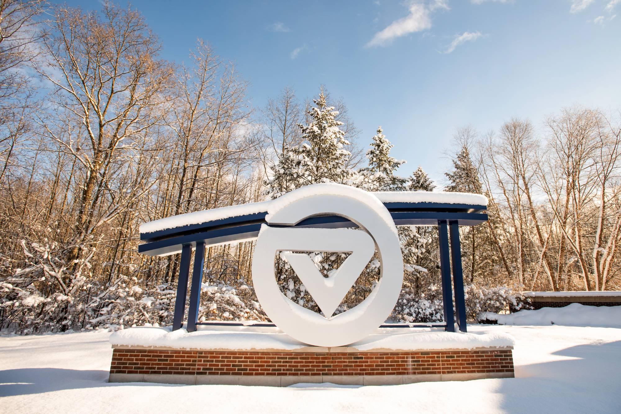 The sign at the entrance to GVSU's Allendale Campus on a snowy, sunny day.